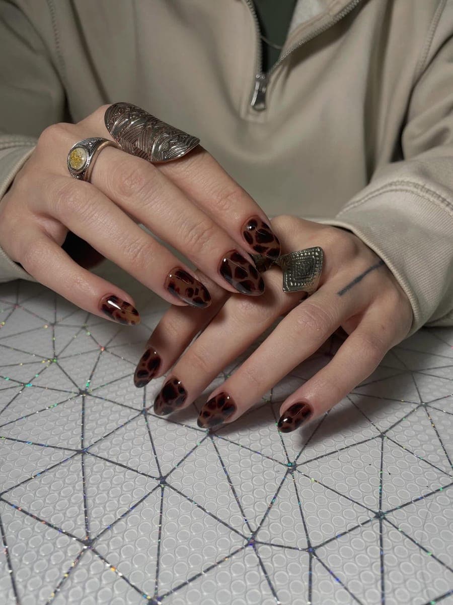 Tortoiseshell leopard-print nails with statement silver rings