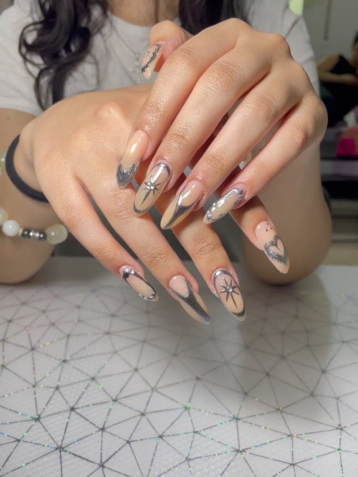 Nude almond nails with silver chrome French tips and star art